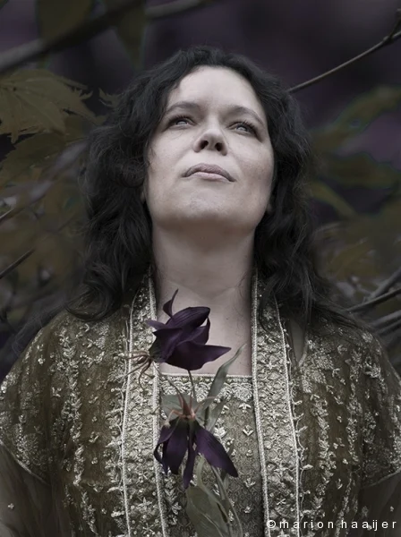 Portret van een vrouw tussen bloemen en takken