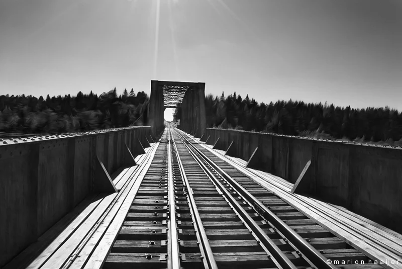 Spoorrails over een brug die verdwijnen in de verte